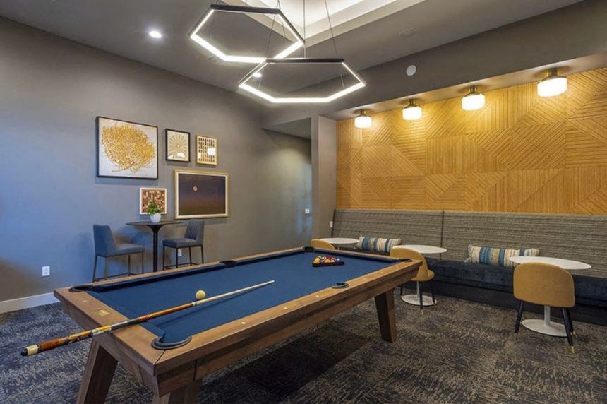 a game room with a pool table and chairs