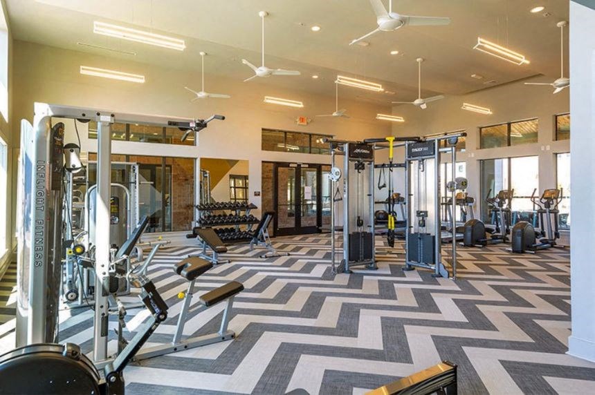 the gym has a lot of weights and equipment in it