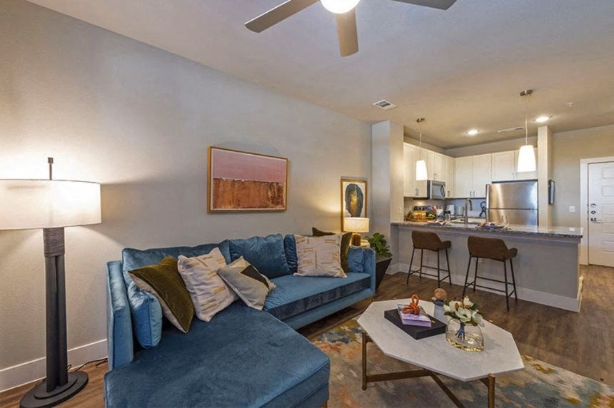 a living room and kitchen with a blue couch and a table