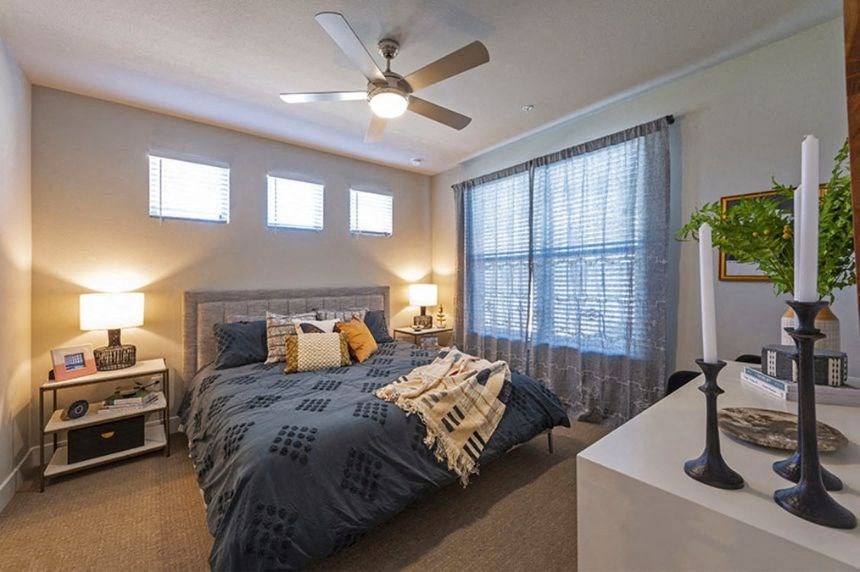 a bedroom with a bed and a ceiling fan