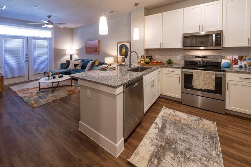a kitchen with an island and a living room