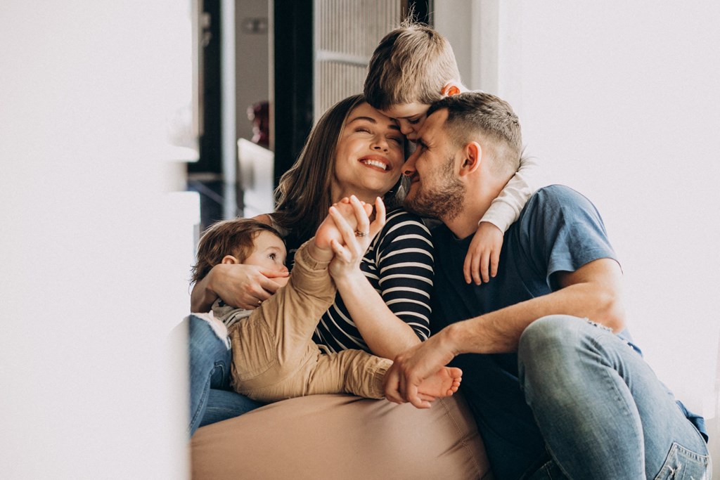 a man and woman sitting on a couch with two children