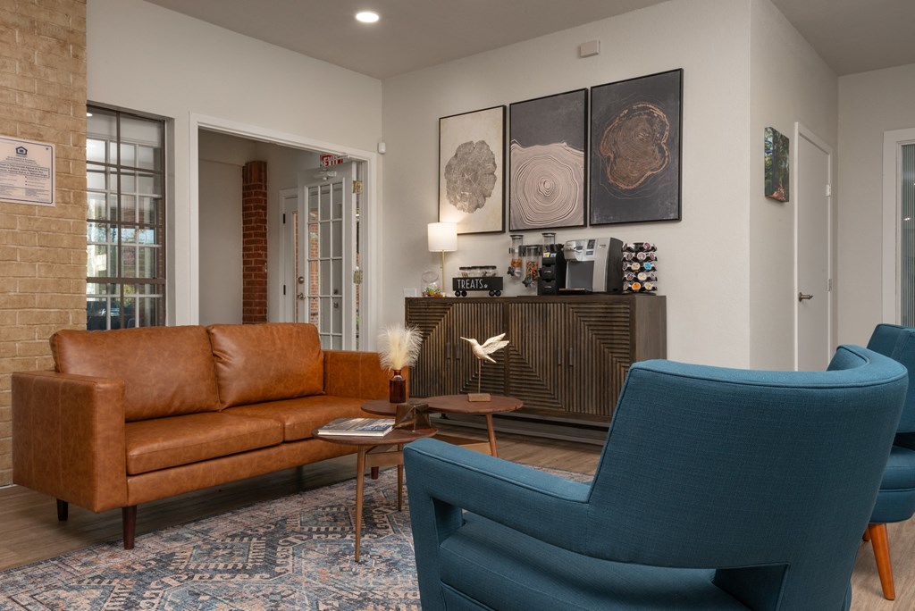 a living room with a brown couch and two blue chairs