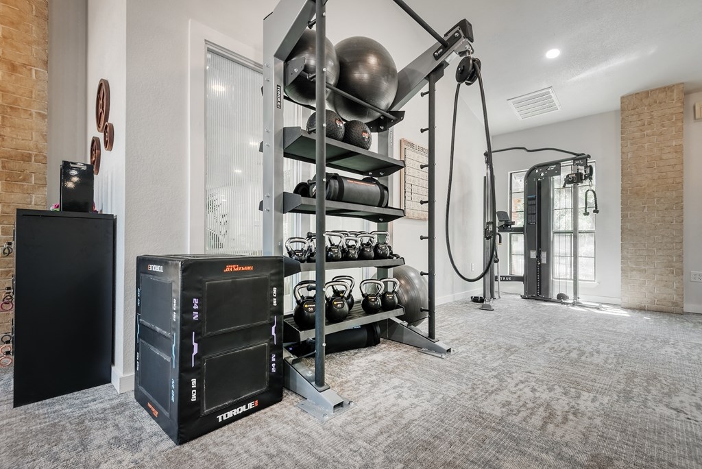 a home gym with a large exercise machine and dumbbells