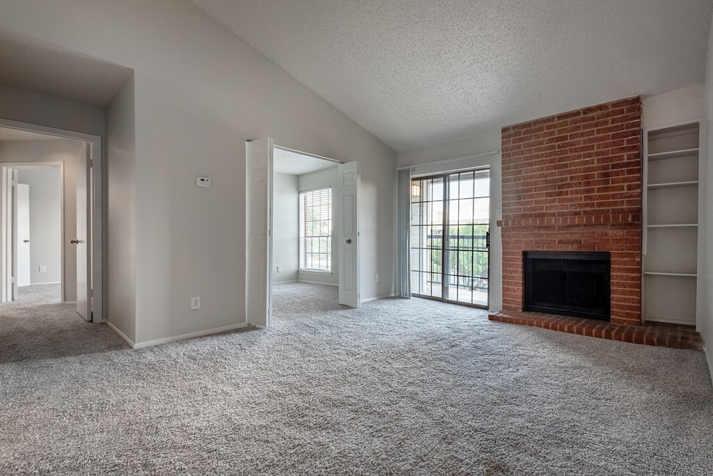 an empty living room with a fireplace and a window