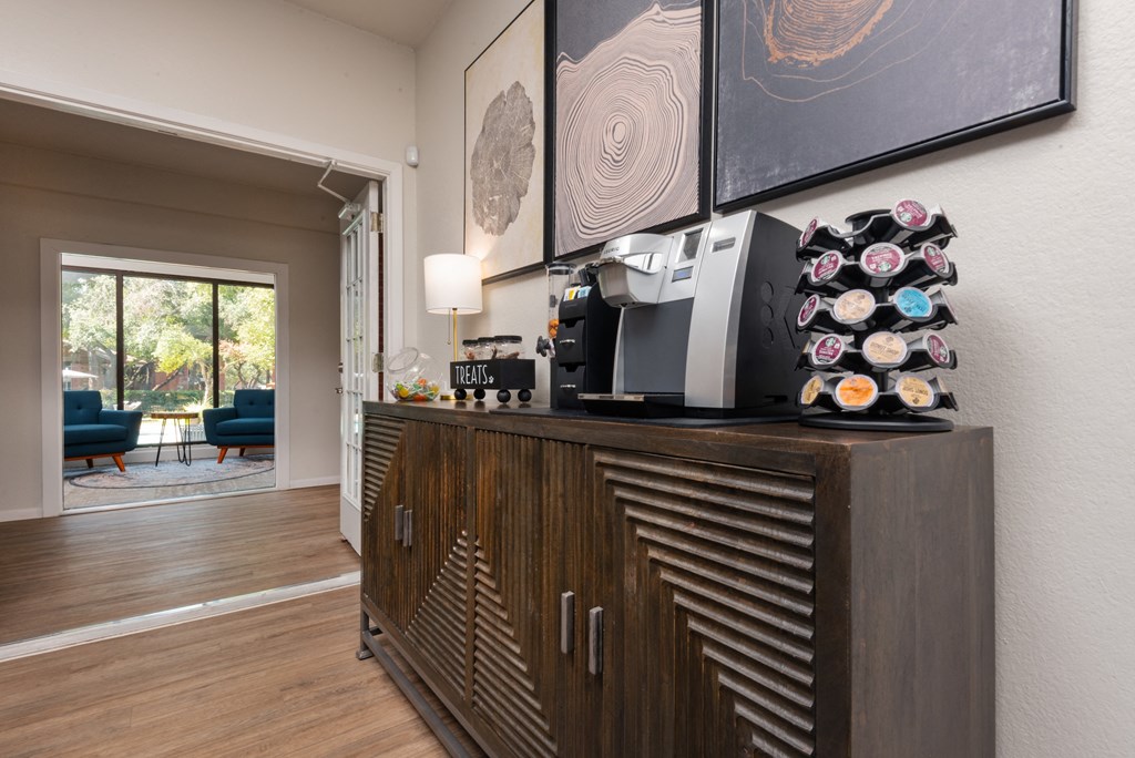 a living room with a cabinet with a coffee maker and a printer on it