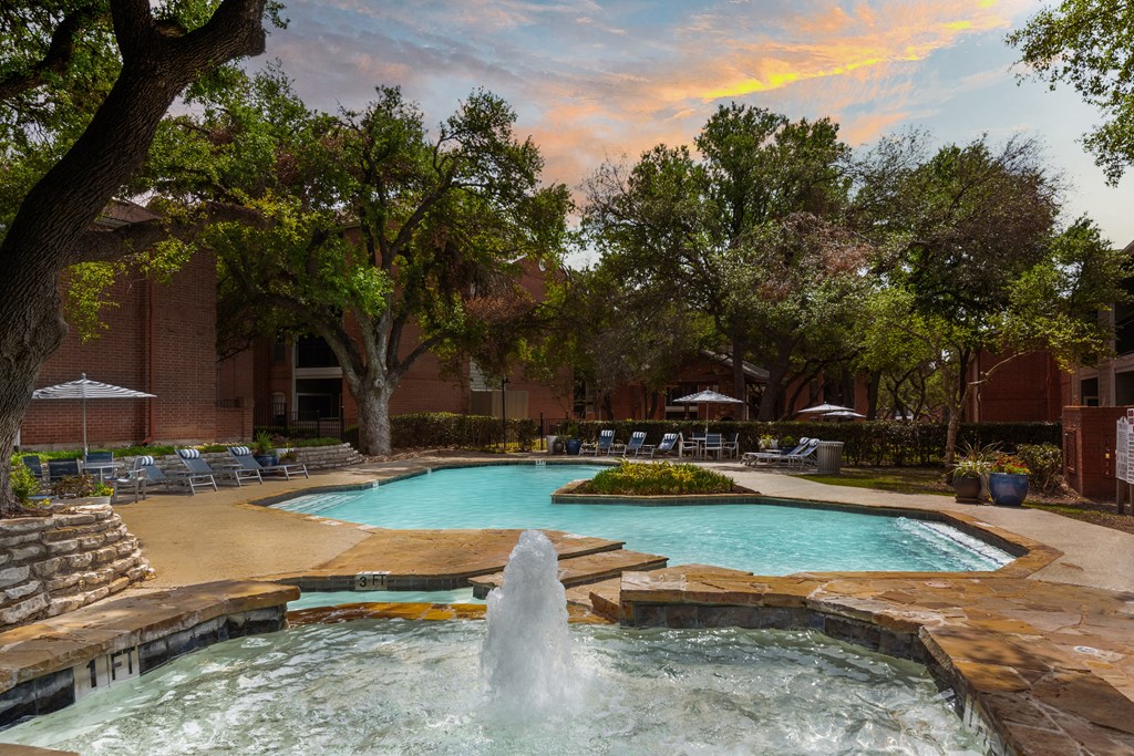 a swimming pool with a fountain in front of a building
