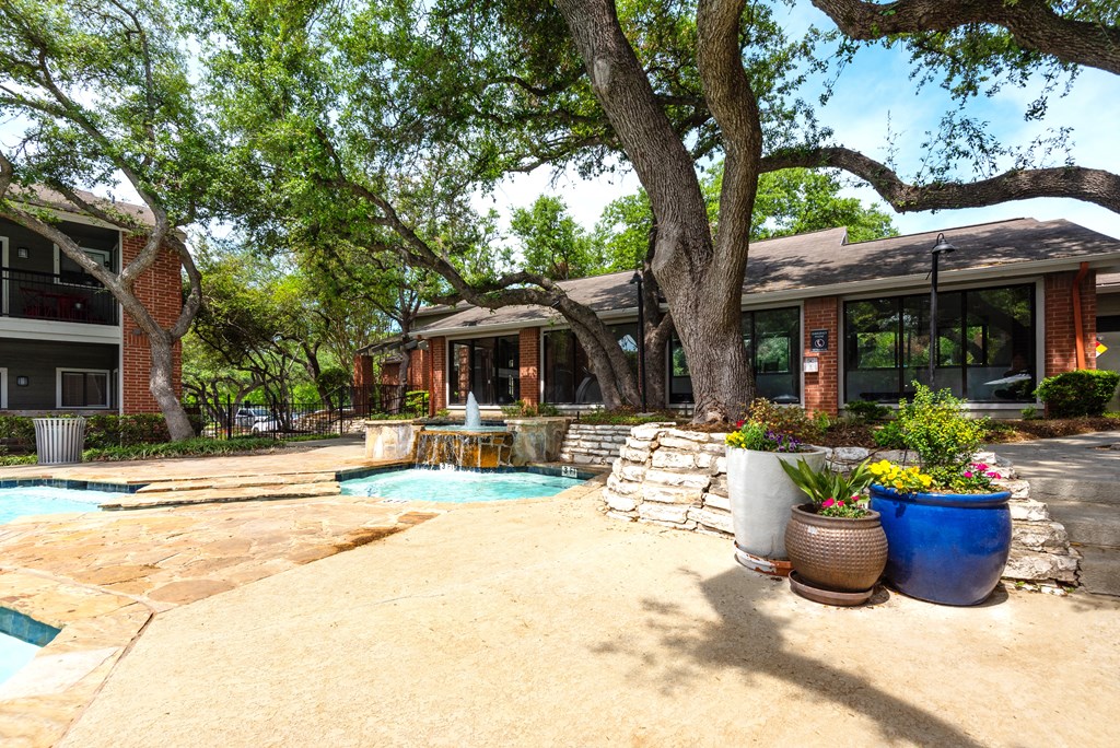 a house with a pool and trees in front of it