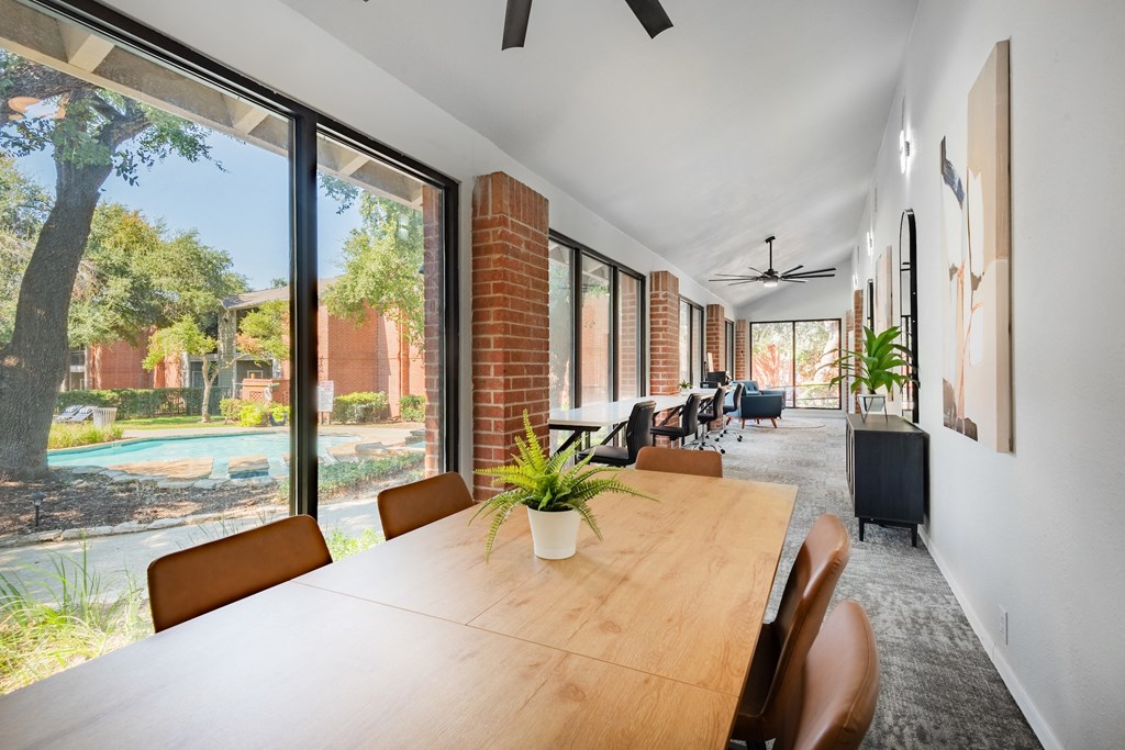 a large dining room with a wooden table and chairs and large windows