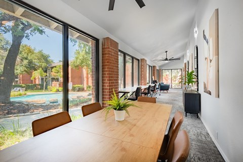 a large dining room with a wooden table and chairs and large windows