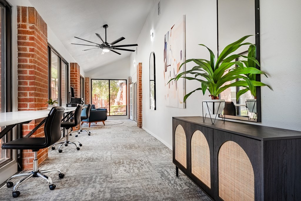 a conference room with a desk and chairs and a large window