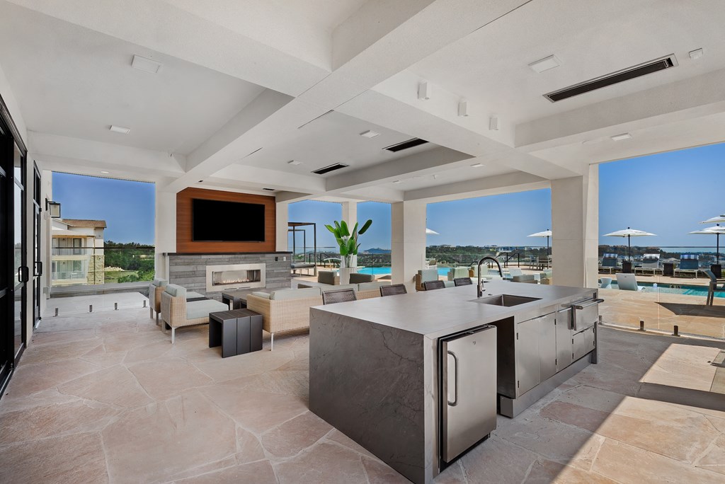 a large living room with a kitchen and a television