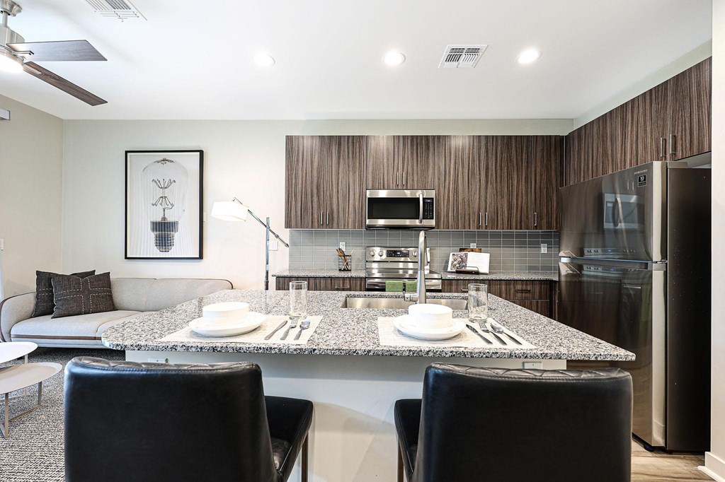 a kitchen and living room with a large island with a granite countertop  at Scottsdale Hayden Townhomes, Scottsdale, 85257