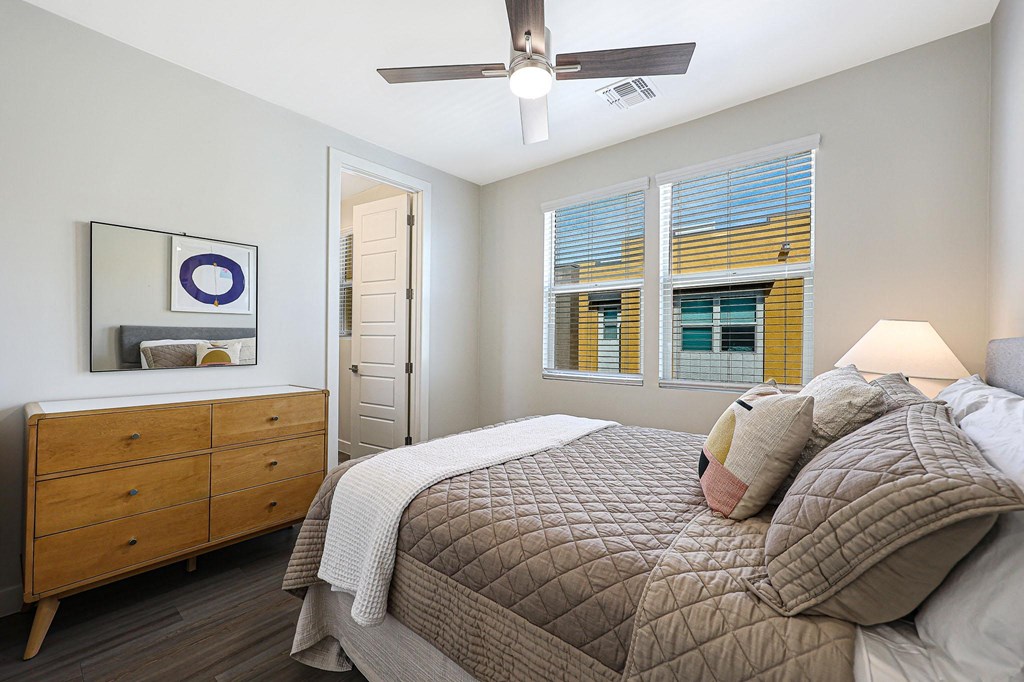 a bedroom with a large bed and a dresser with a mirror  at Scottsdale Hayden Townhomes, Arizona