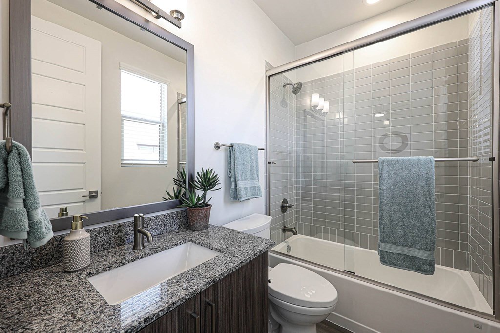 a bathroom with gray tile and a white toilet at Scottsdale Hayden Townhomes, Arizona, 85257