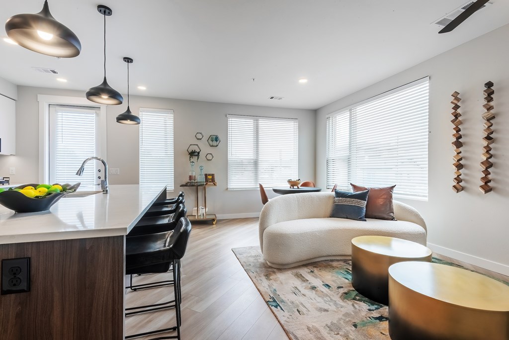 A modern kitchen with a black chair and a bowl of lemons on the counter.