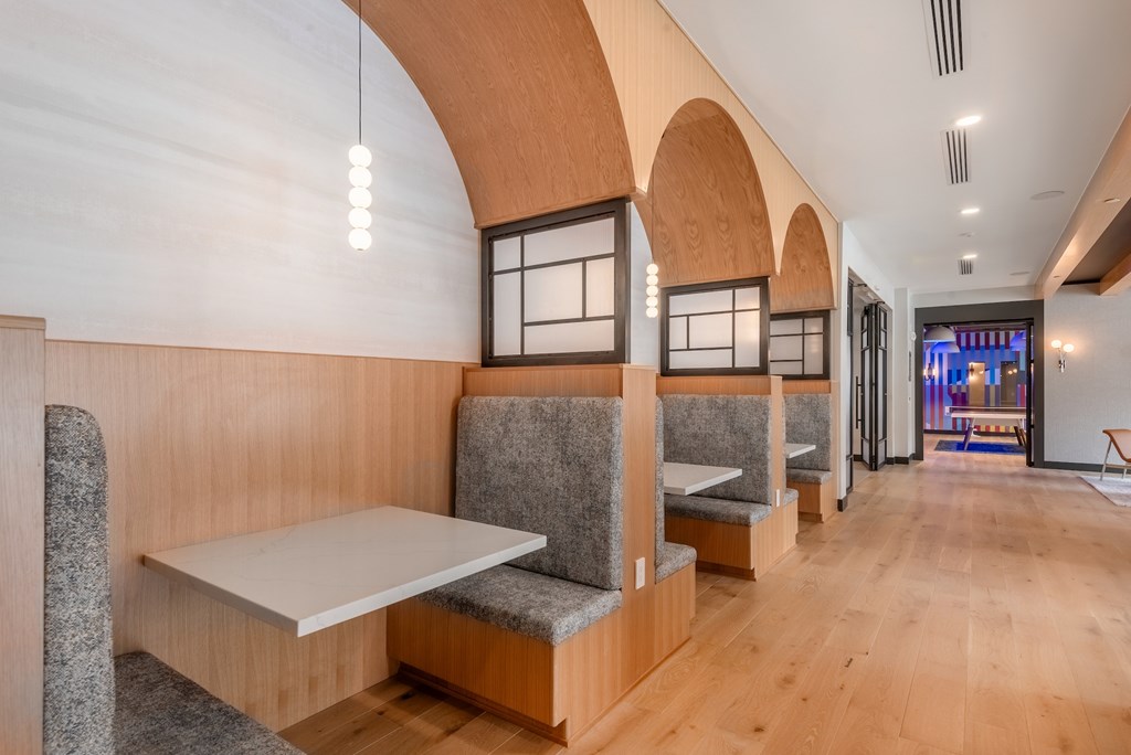 A long hallway with benches and tables on the side.