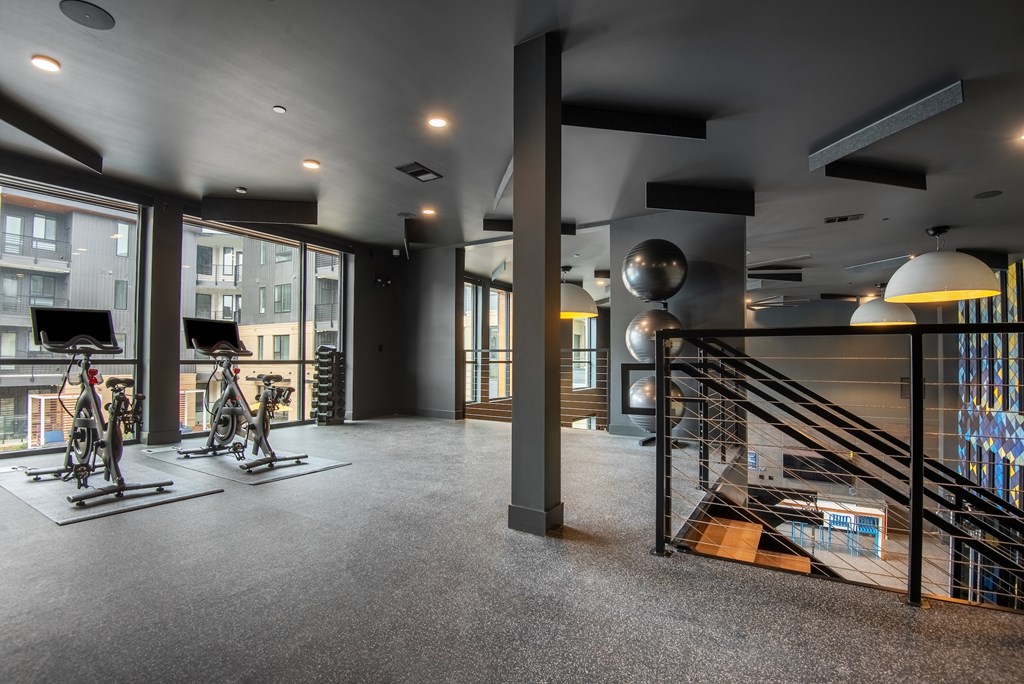 A room with a grey carpet and a black railing.
