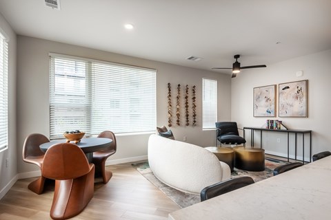 A living room with a brown chair and a white sofa.