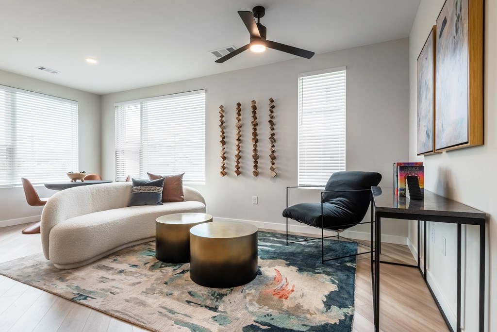 A living room with a black chair and a rug.