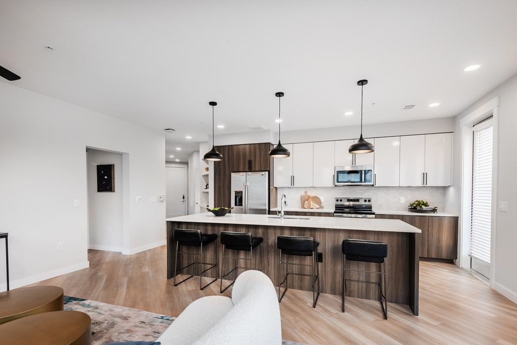 A modern kitchen with a bar area and a dining table.