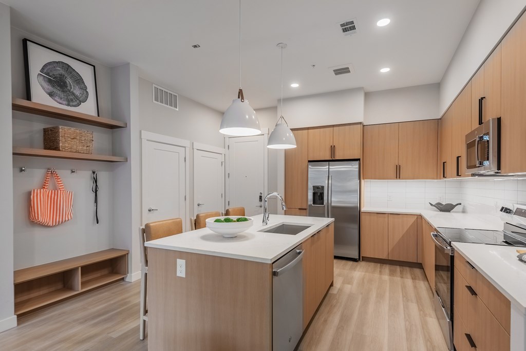 A modern kitchen with wooden cabinets and a white island.