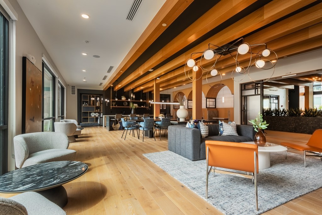 A modern living room with a wooden ceiling and furniture.