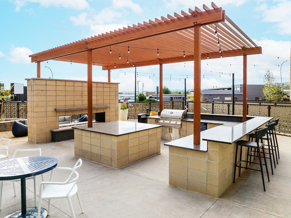 A patio with a table, chairs and a bar.