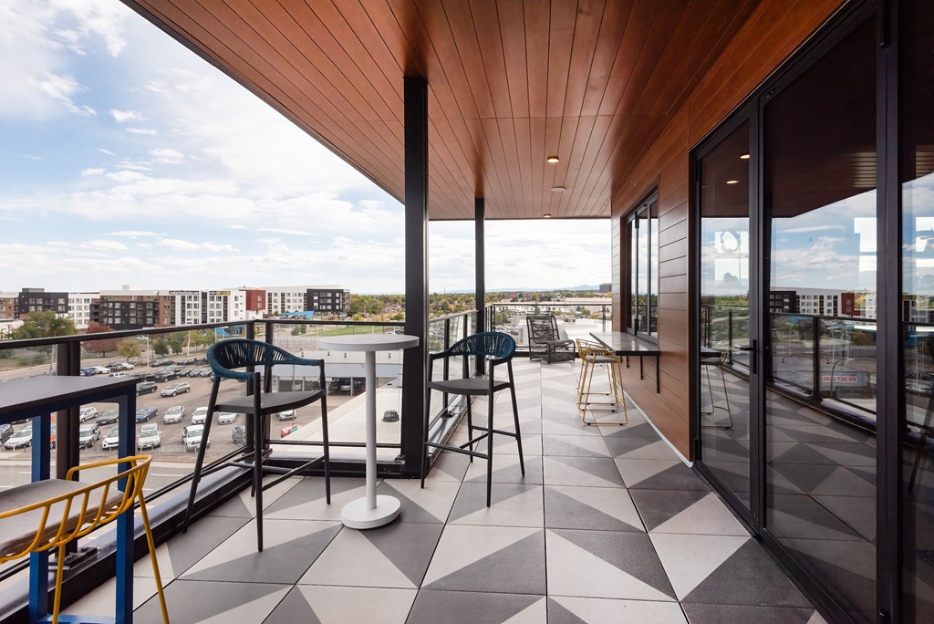 A balcony with a black and white checkered floor and a yellow chair.