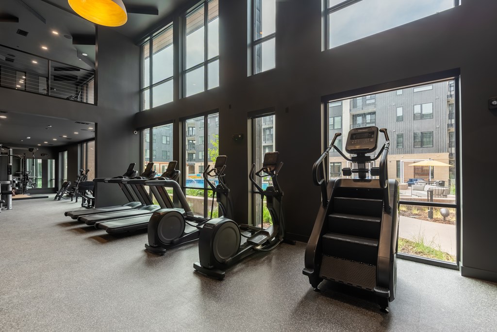 A gym with treadmills, elliptical machines, and a stair climber.
