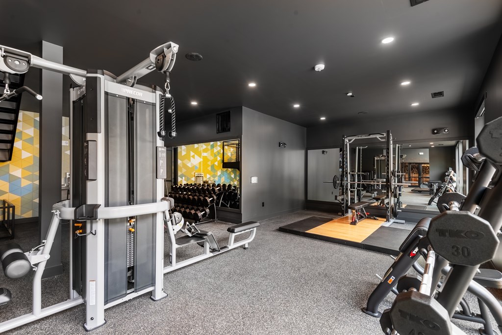 A gym with a variety of equipment including weights and machines.