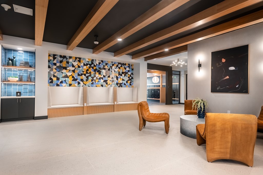 A modern waiting room with wooden furniture and a mosaic tile wall.