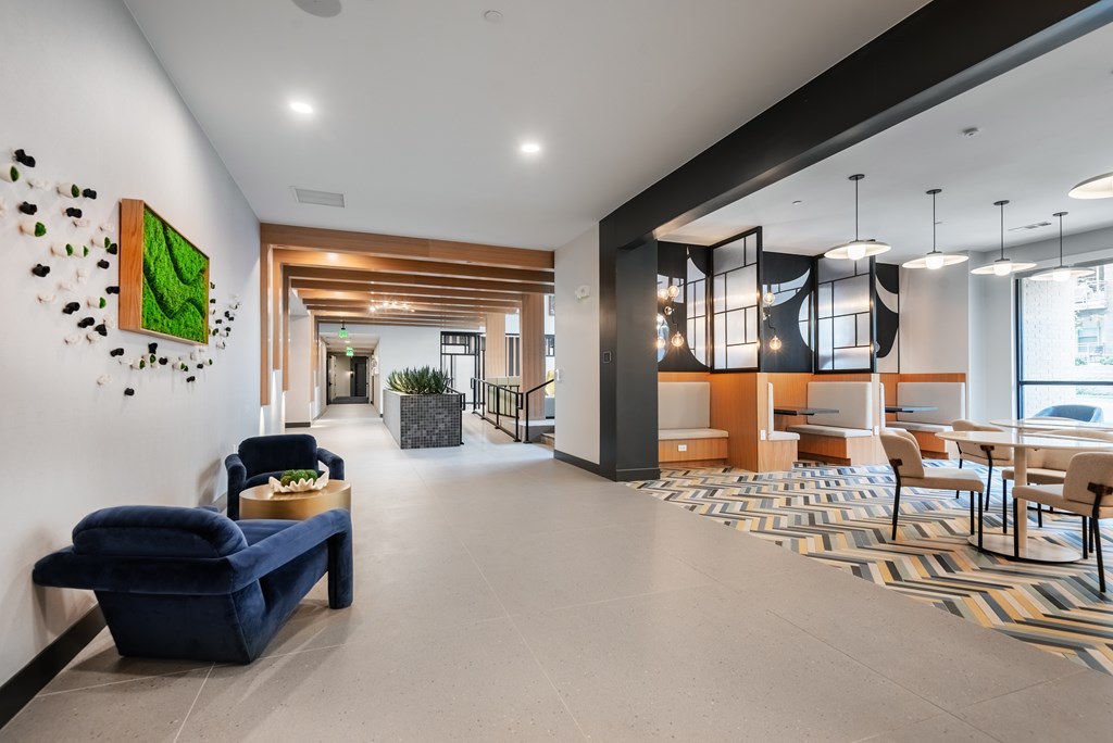 A modern living room with a blue sofa and a green abstract painting on the wall.