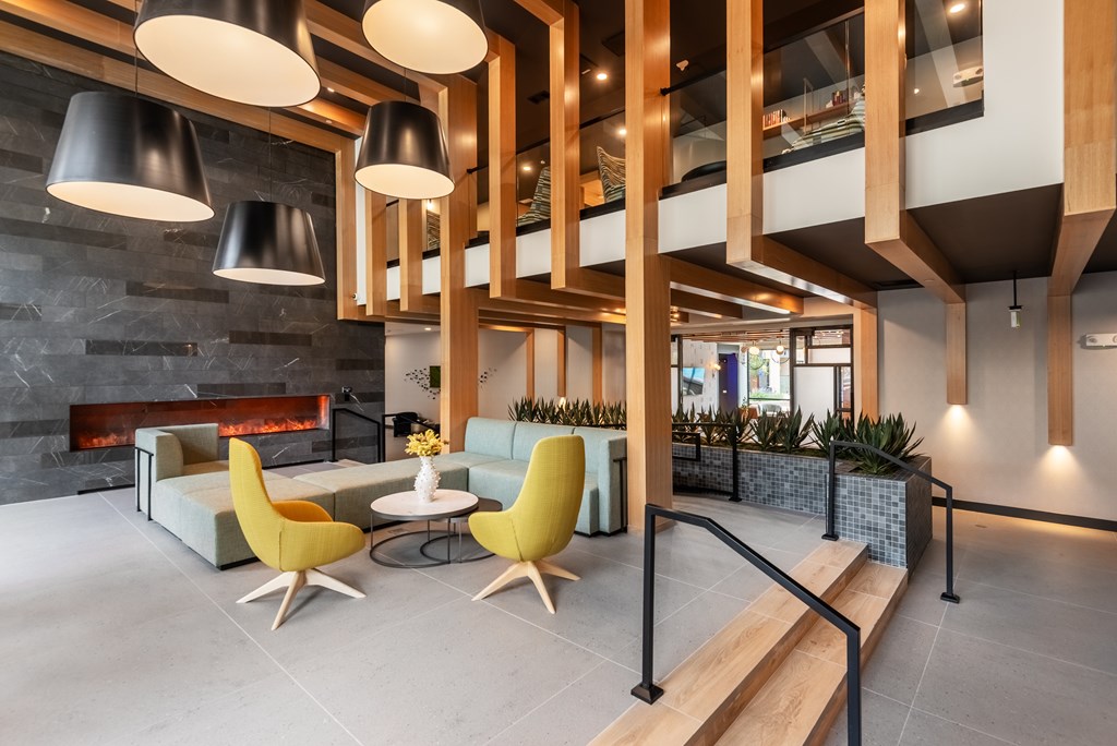 A modern interior with a fireplace and yellow chairs.