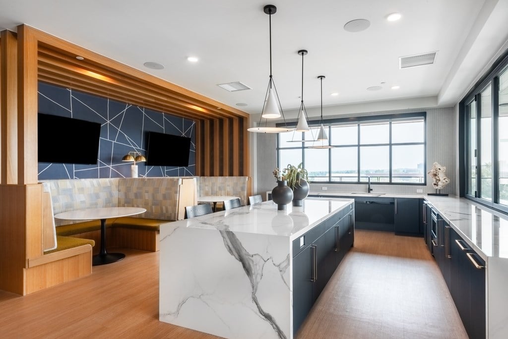 A modern kitchen with a marble island and wooden accents.