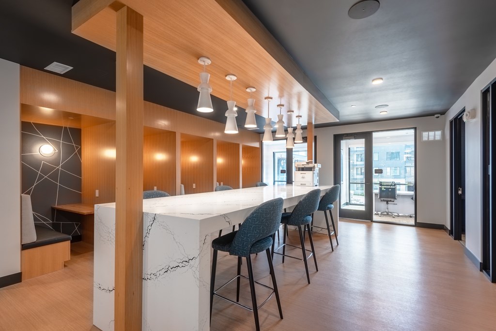 A modern office space with a long white table and blue chairs.