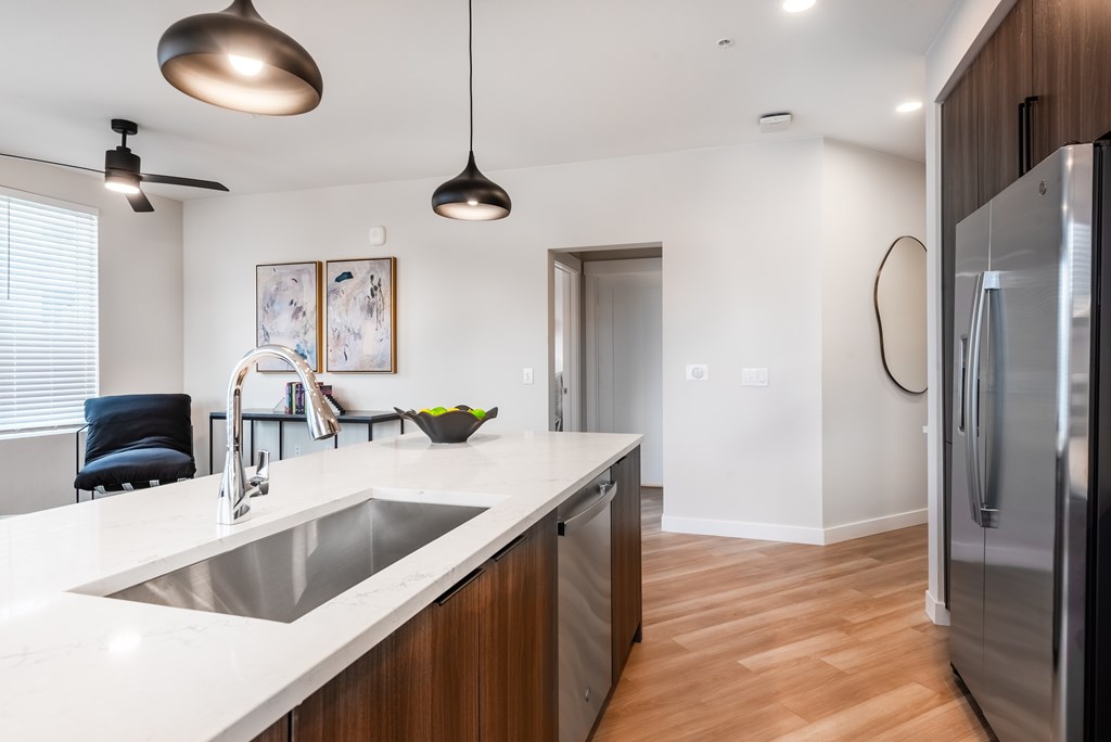 A modern kitchen with a stainless steel refrigerator and a white countertop.