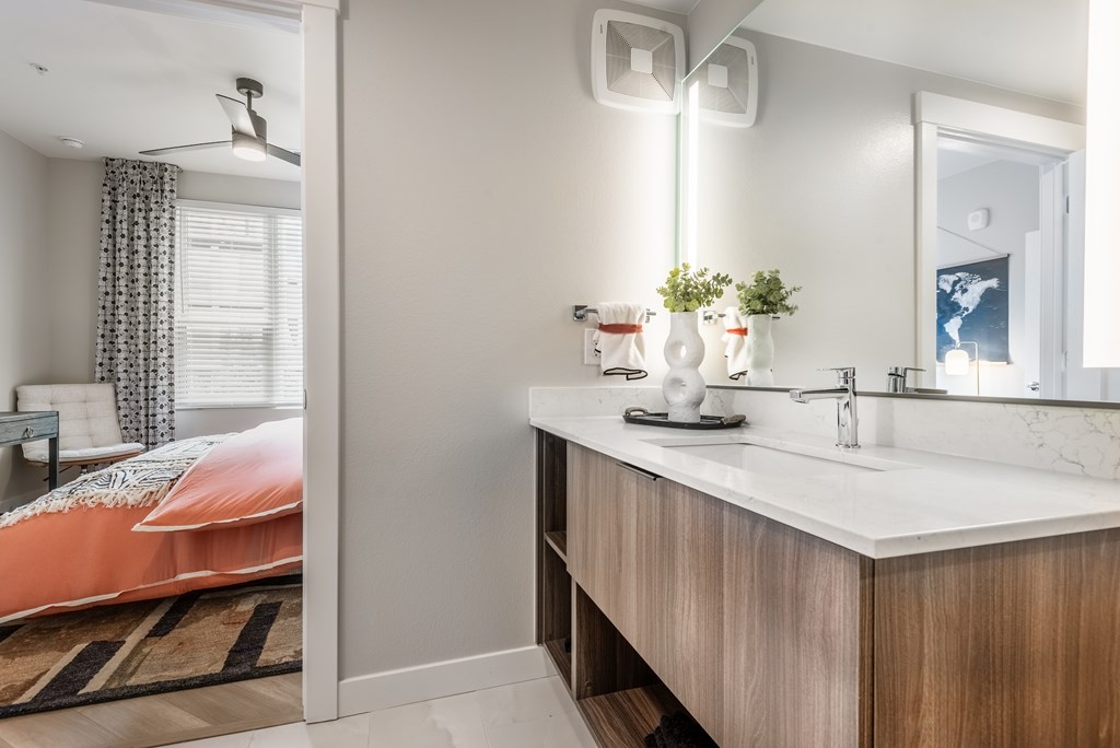 A bathroom with a bedroom area visible through the open door.