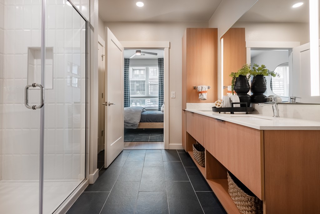 A modern bathroom with a walk-in shower and a double sink vanity.