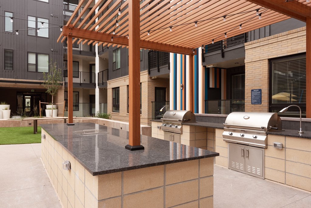 A modern outdoor kitchen with a grill and sink.