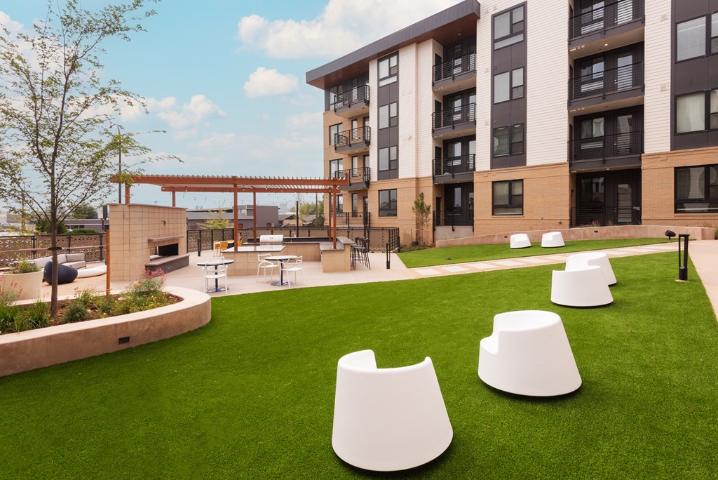 A modern building with a grassy area in front of it.