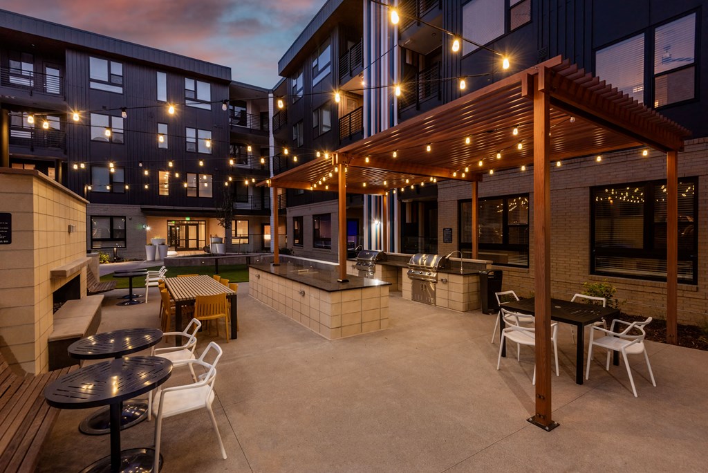 A patio area with tables and chairs under a pergola.