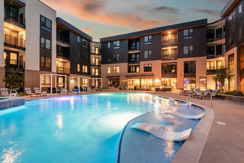 A large swimming pool in front of apartment buildings.