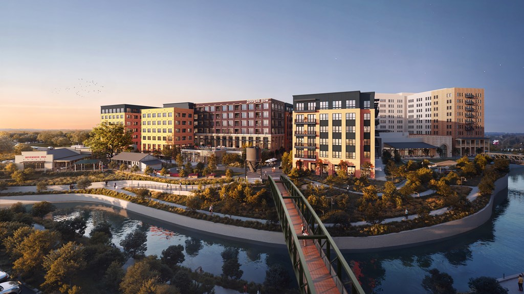 A modern building complex with a bridge over a body of water.