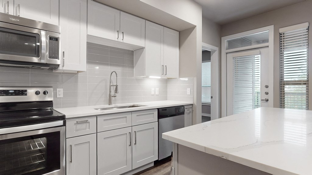 Apartment kitchen with white cabinets at The Can Plant Residences at Pearl, San Antonio, TX 78215and a white counter top  at The Can Plant Residences at Pearl, San Antonio, TX