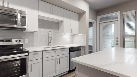 Apartment kitchen with white cabinets at The Can Plant Residences at Pearl, San Antonio, TX 78215and a white counter top  at The Can Plant Residences at Pearl, San Antonio, TX