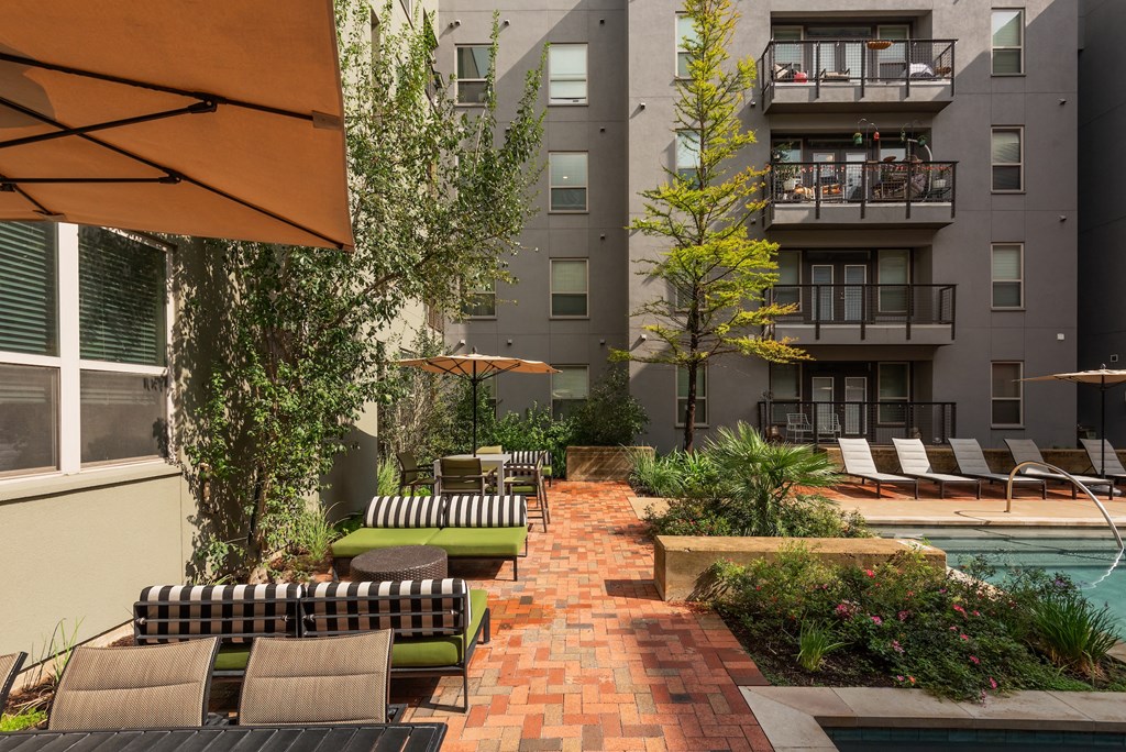 Courtyard with a pool and lounge chairs at The Can Plant Residences at Pearl, San Antonio, TX 78215