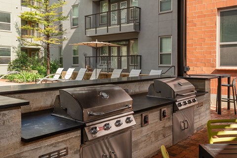 utdoor grill area with chairs and stainless steel appliances  at The Can Plant Residences at Pearl, San Antonio, TX