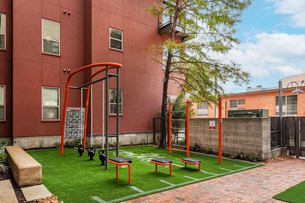 A playground with grass and bench at  The Can Plant Residences at Pearl, San Antonio, TX 78215