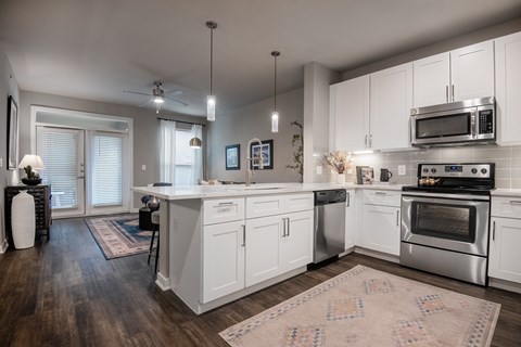 a kitchen with white cabinets and stainless steel appliances at The Can Plant Residences at Pearl, San Antonio